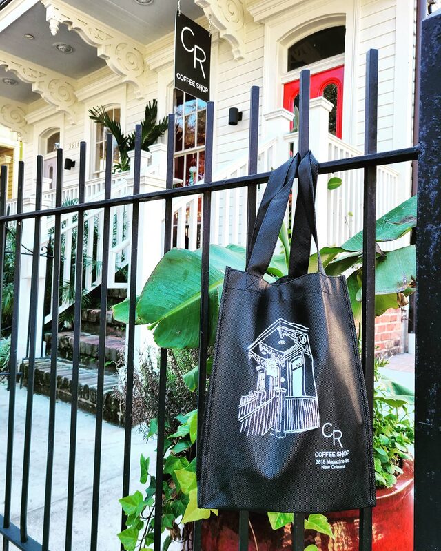 CR Coffee tote bag on fence with shotgun house exterior